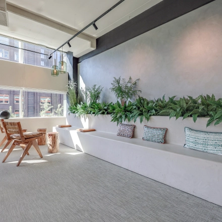 Bright, modern office space rental at Gustav Mahlerlaan 308, Amsterdam Zuidas, featuring a stylish, furnished interior with seating and greenery.