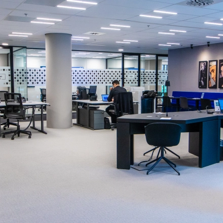 Modern office space rental at Gustav Mahlerplein in Amsterdam Zuidas with people working on laptops at desks, featuring open workspaces with contemporary furniture.