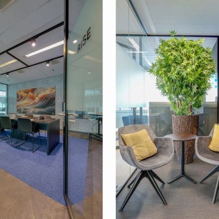 Interior view of a furnished office space at Gustav Mahlerplein 28 & 58-60 in Amsterdam Zuidas, featuring a conference room with chairs and a small lounge area with chairs and a plant.
