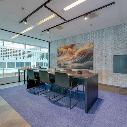 Spacious conference room in Amsterdam Zuidas with a large table, chairs, and modern decor, ideal for office space rental.