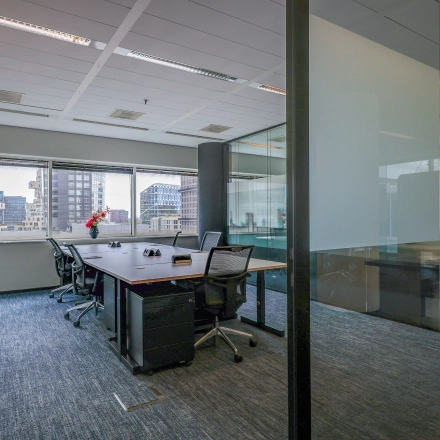 Modern office space at Gustav Mahlerplein in Amsterdam Zuidas, featuring a furnished interior with desks and chairs, available for rent.