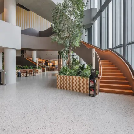 Modern office space with a stylish staircase and lush greenery, ideal for office space rental in Amsterdam Zuidas.