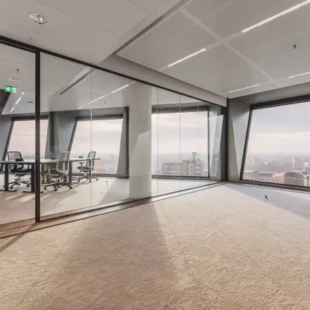 Modern office space for rent at Hildegard Von Bingenstraat 44, Amsterdam Zuidas, featuring large windows with city views and a glass-walled meeting room.