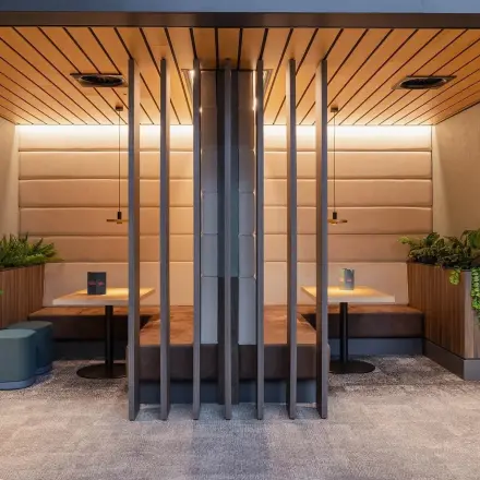 Modern furnished office space at Jachthavenweg 109, Amsterdam Zuidas, featuring cozy seating booths and greenery. Perfect for office space rental.