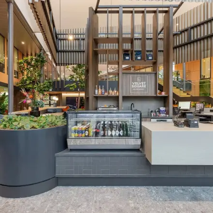 Modern office space at Jachthavenweg 109 in Amsterdam Zuidas featuring a stylish reception area with a beverage cooler and plants, ideal for those seeking office space rental.