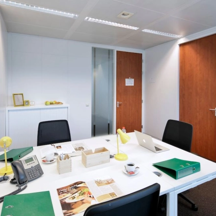 Interior office space at Lange Lozanastraat 142, Antwerp Center, featuring a furnished workspace with a white table, office chairs, and various desk items ideal for office space rental.