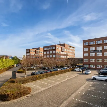 Exterior view of Het Rietveld 55-59 in Apeldoorn, showcasing multiple office buildings with ample parking space, ideal for office space rental.