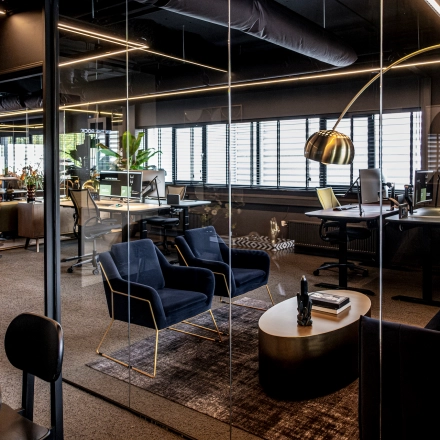 Modern office space in Apeldoorn with stylish furnishings, glass walls, and desks set up for work. Ideal for those looking to rent office space or interested in office space rental.
