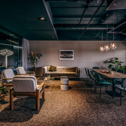 Stylish office space available for rent at Lange Amerikaweg 55-61, Apeldoorn, featuring a furnished area with modern seating and a large meeting table.