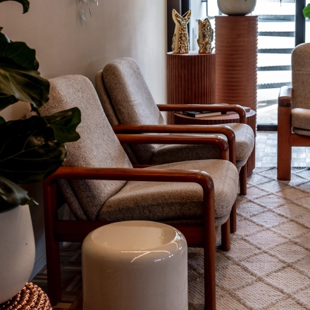 Cozy waiting area with comfortable chairs, decorative plants, and stylish tables at an office to rent in Lange Amerikaweg, Apeldoorn.