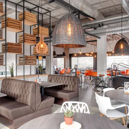 Modern office space rental at Oude Apeldoornseweg 41-45 with stylish seating, wooden accents, and a cozy atmosphere.