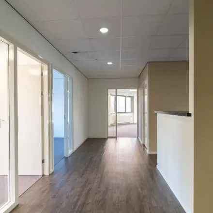 Hallway in an office at Prins Willem-Alexanderlaan 401, Apeldoorn, ideal for office space rental with rooms branching off. A sleek and neutral interior ready for rent.