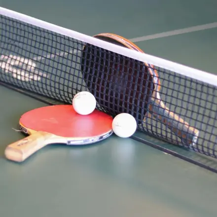 Table tennis setup with paddles and balls on a table, indicating a recreational area at the office space rental on Prins Willem-Alexanderlaan 401, Apeldoorn.
