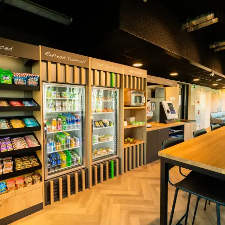 Modern office pantry at Prins Willem Alexanderlaan 701, Apeldoorn, offering a variety of snacks and beverages alongside seating options, perfect for a break during your office space rental.