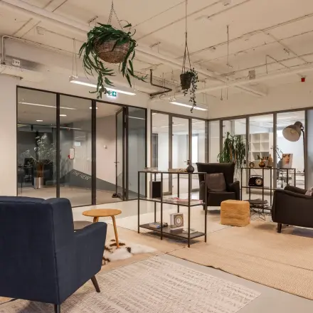 Comfortable office space at Roggestraat 111, Apeldoorn, featuring modern seating and decorative plants, available for rent.