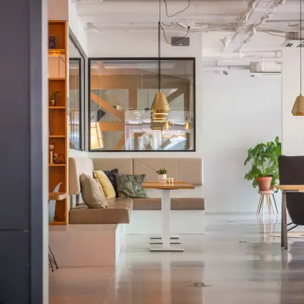 Bright and modern furnished office space on Roggestraat 111, featuring cozy seating areas and stylish decor, perfect for office space rental.