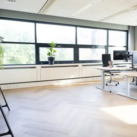 Bright office space in Schumanpark 9, Apeldoorn, featuring modern desks and large windows, perfect for those seeking office space rental.