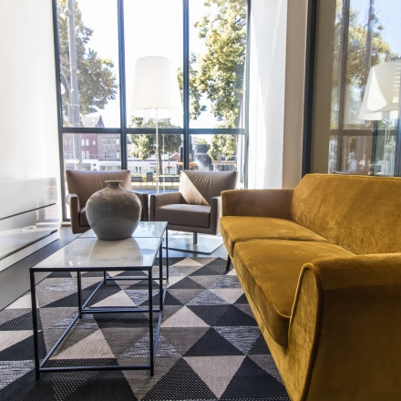 Furnished office space at Jansbuitensingel 7 in Arnhem Centrum with modern seating and large windows, ideal for rent office space seekers.