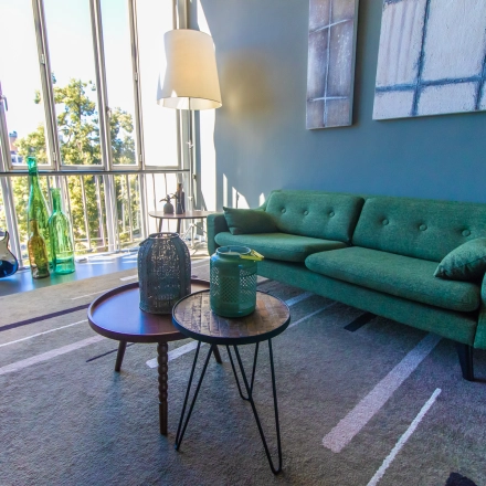Cozy office lounge at Jansbuitensingel 7, Arnhem Centrum, ideal for office space rental, featuring plush seating and large windows with a view.