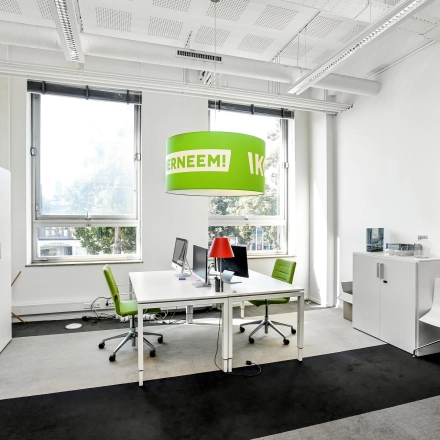 Bright furnished workspace at Jansbuitensingel 7, Arnhem Centrum, ideal for office space rental with modern desks, chairs, and large windows.