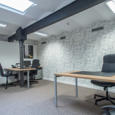 Interior view of a furnished office space with desks and chairs, located at Carrer d'Aribau 161 in Barcelona Eixample, ideal for office space rental.