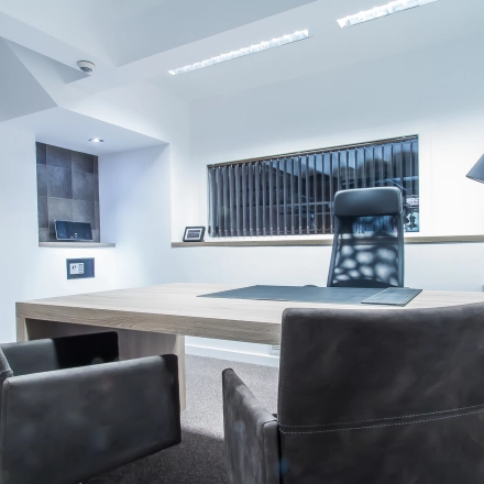 Furnished office space available for rent at Carrer d'Aribau 161, Barcelona Eixample, featuring a stylish desk and chairs, with modern lighting and decor.