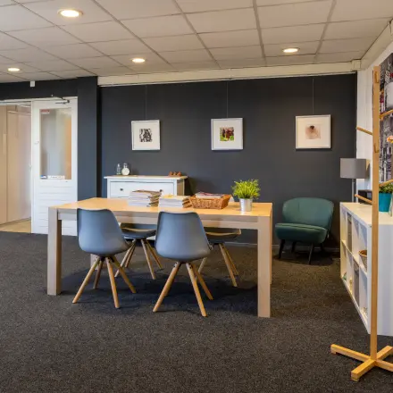Inviting office space at Kamerlingh Onnesweg 10, Barendrecht, featuring a modern table with chairs, wall art, and a cozy seating area, ideal for rent office space needs.