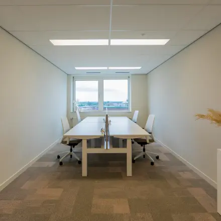 Interior view of a furnished office space rental at Baron van Nagellstraat 136, Barneveld with two desks and chairs, offering a bright and simple working environment.