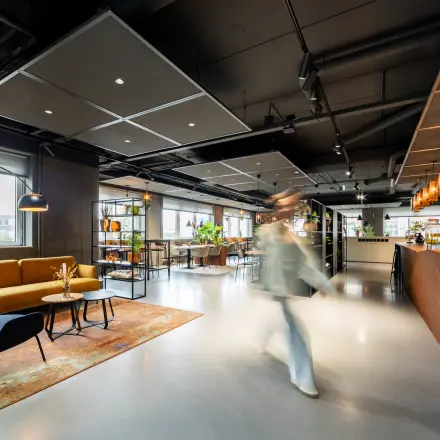 Modern office interior at Baron van Nagellstraat 136, Barneveld, featuring stylish furnishings and a person walking through the workspace. An inviting option for office space rental.