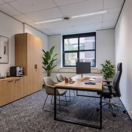 Bright office space rental at Rijtuigweg 10, Bergen op Zoom featuring a modern desk, ergonomic chair, and window with a view.