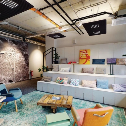 Furnished office space at Koppenstraße 93 in Berlin Friedrichshain, featuring vibrant seating and a large map wall for creative meetings and collaboration.