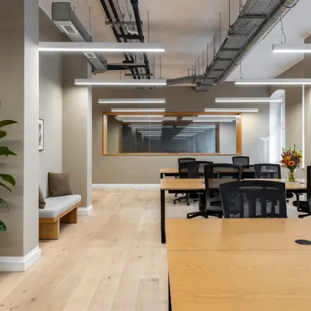 Interior view of a furnished office to rent at Chausseestraße 29, Berlin Kreuzberg, featuring modern desks and chairs arranged in a spacious layout.