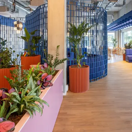 Vibrant office space at Heidestraße 34, Berlin Mitte, featuring colorful seating and decorative plants, perfect for working or meeting. Ideal for those looking to rent office space in a stylish environment.