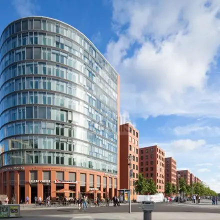 Office building with a modern curved glass facade at Potsdamer Platz 10, perfect for those seeking office space rental in Berlin Mitte.