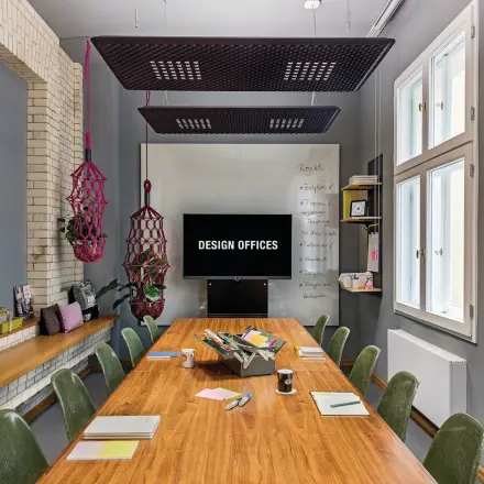 Furnished office space rental in Berlin Mitte with a large wooden table, chairs, and colorful decor perfect for creative meetings.