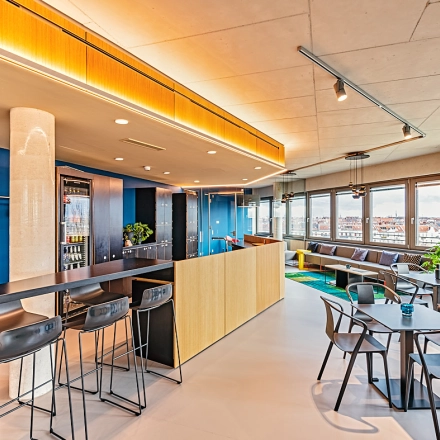 Modern office space for rent in Berlin Schöneberg at EUREF-Campus 22, featuring stylish furnishings, a mix of seating options, and expansive windows with natural light.