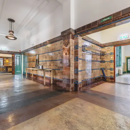 Interior view of an office space at Ceresstraat 13, Breda Centrum-Station, showcasing a tiled hallway with visible doors leading to different rooms, offering potential for office space rental.