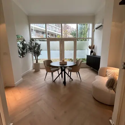 Cozy office space at Sophiastraat 40 40, Breda Centrum-Station, featuring a furnished area with a round table, chairs, and a plush armchair, ideal for office space rental.