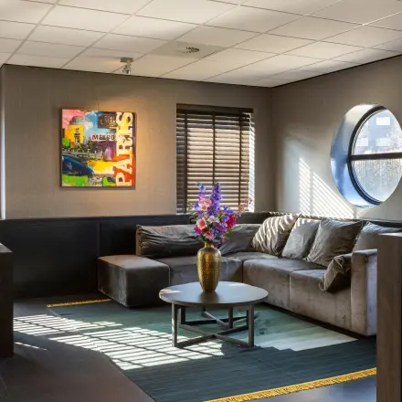 Furnished office space with a comfortable lounge area and modern decor, ideal for rent in Breda Oost-Brabantpark at Takkebijster 57A.