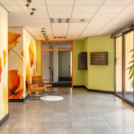 Bright entrance with floral murals at Takkebijster 57A, featuring office space rental opportunities in Breda Oost-Brabantpark.