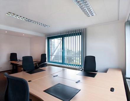Spacious office at Flughafenallee 26 in Bremen Neustadt with multiple workstations, available for rent office space. Bright room with large windows and modern furniture.