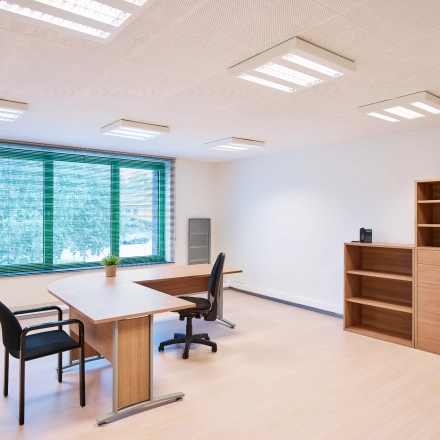 Bright office space with wooden furniture and large window view, available for rent at Leuvensesteenweg 613, Brussels Airport.