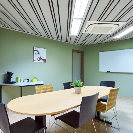 Spacious office to rent at Brussels Airport with a large table, chairs, and a whiteboard, perfect for meetings.
