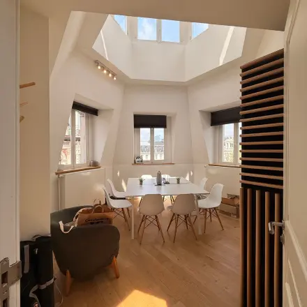 Bright office space at Rue du Congres 37, Brussels Center, featuring a skylight and modern furnishings ideal for rental.