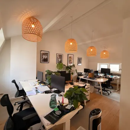 Well-lit office space with modern workstations and stylish lighting in Brussels Center, ideal for office space rental.
