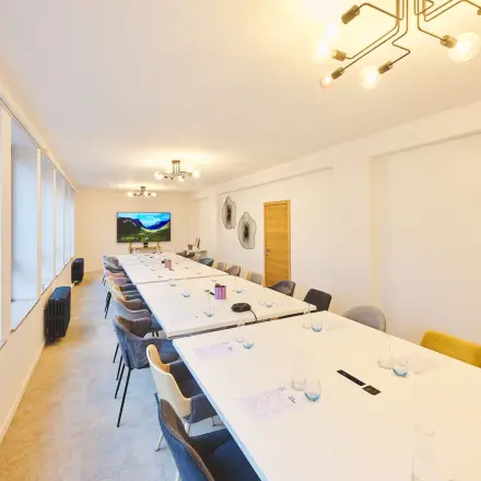 Spacious conference room at Rue du Congres 37, Brussels Center, featuring modern lighting and long tables ideal for office space rental.