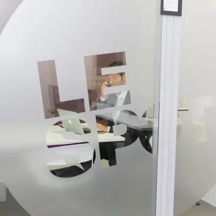 Interior view of an office space rental on Rue Joseph Stevens 7, Brussels Center, featuring a person working at a desk with a laptop.