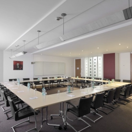 Spacious conference room at Louizalaan/Avenue Louise 65 in Brussels Elsene with a large table and chairs set up for a meeting, ideal for office space rental.