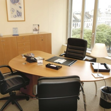 Bright office space with two chairs facing a large desk and a window view at Louizalaan / Avenue Louise 65, ideal for office space rental.