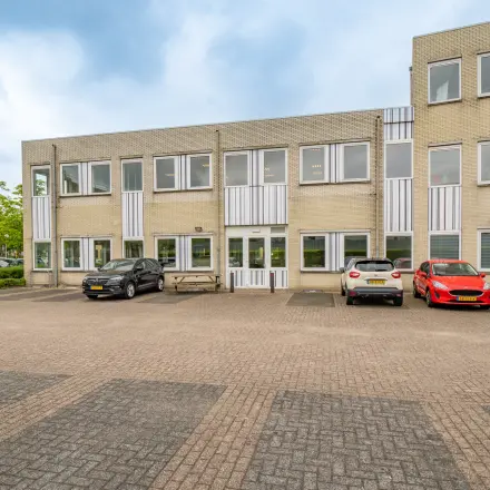 Exterior view of office space for rent at Regulierenring 2, Bunnik, showing a two-story building with parking area.